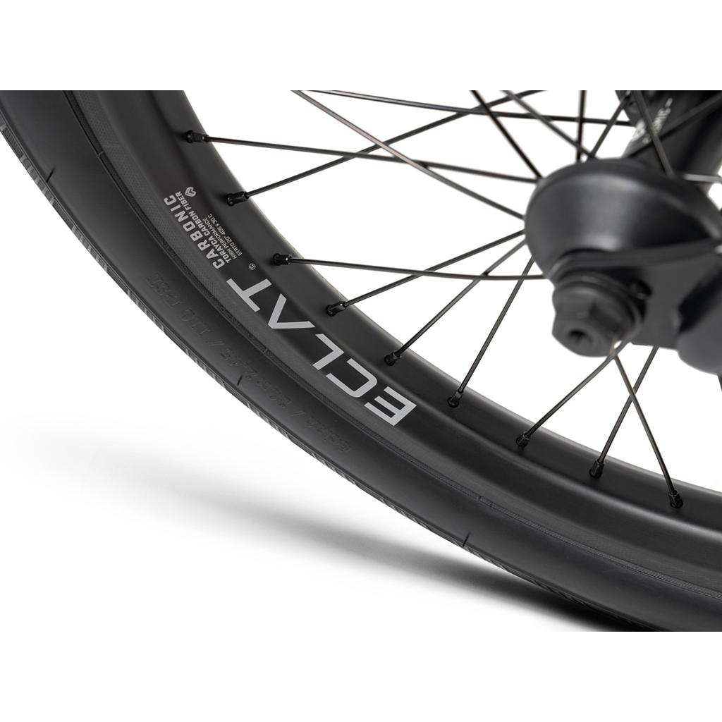 Close-up of the Wethepeople 20 inch Envy Carbonic LTD Bike’s black wheel, showing carbon fibre rim with "ECLAT" and "CARBONIC" branding, plus detailed view of spokes, rim, and tire on this BMX.