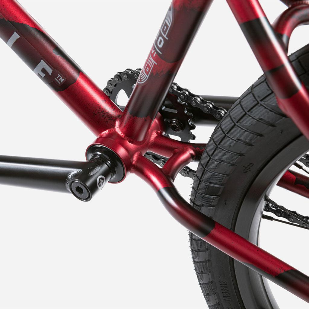 Close-up view of the Wethepeople Audio 22 Inch Bike's rear wheel and chromoly frame, showcasing the chain, tire, and part of the pedal.