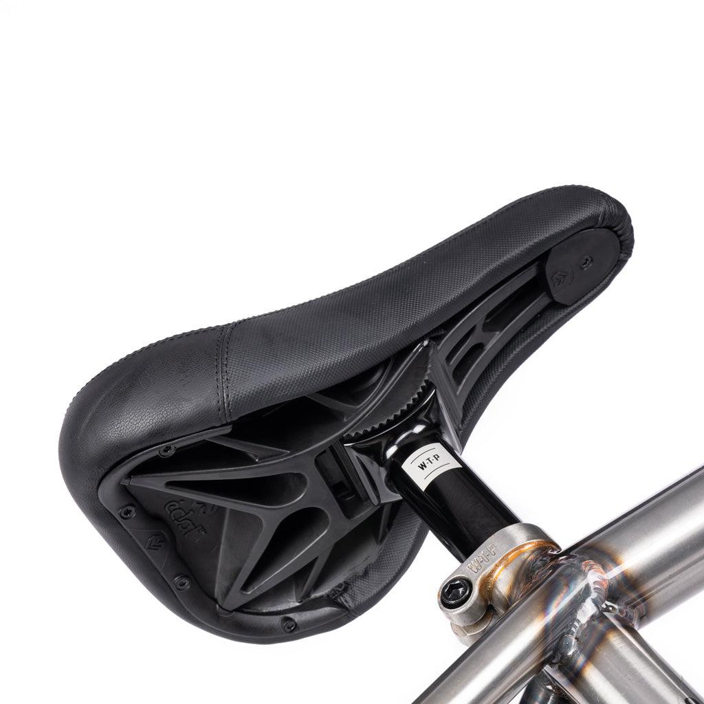 Close-up view of a black bicycle seat mounted on the metallic seat post of the Wethepeople Battleship 20 Inch Bike, showing the underside and Eclat components hardware.