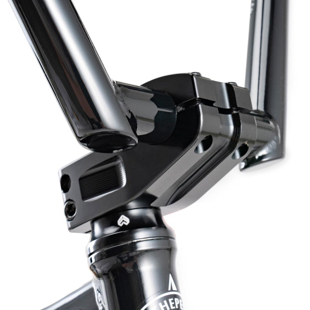 Close-up of the Wethepeople Battleship 20 Inch Bike's black BMX stem and handlebar assembly, highlighting the joints and bolts against a white background.