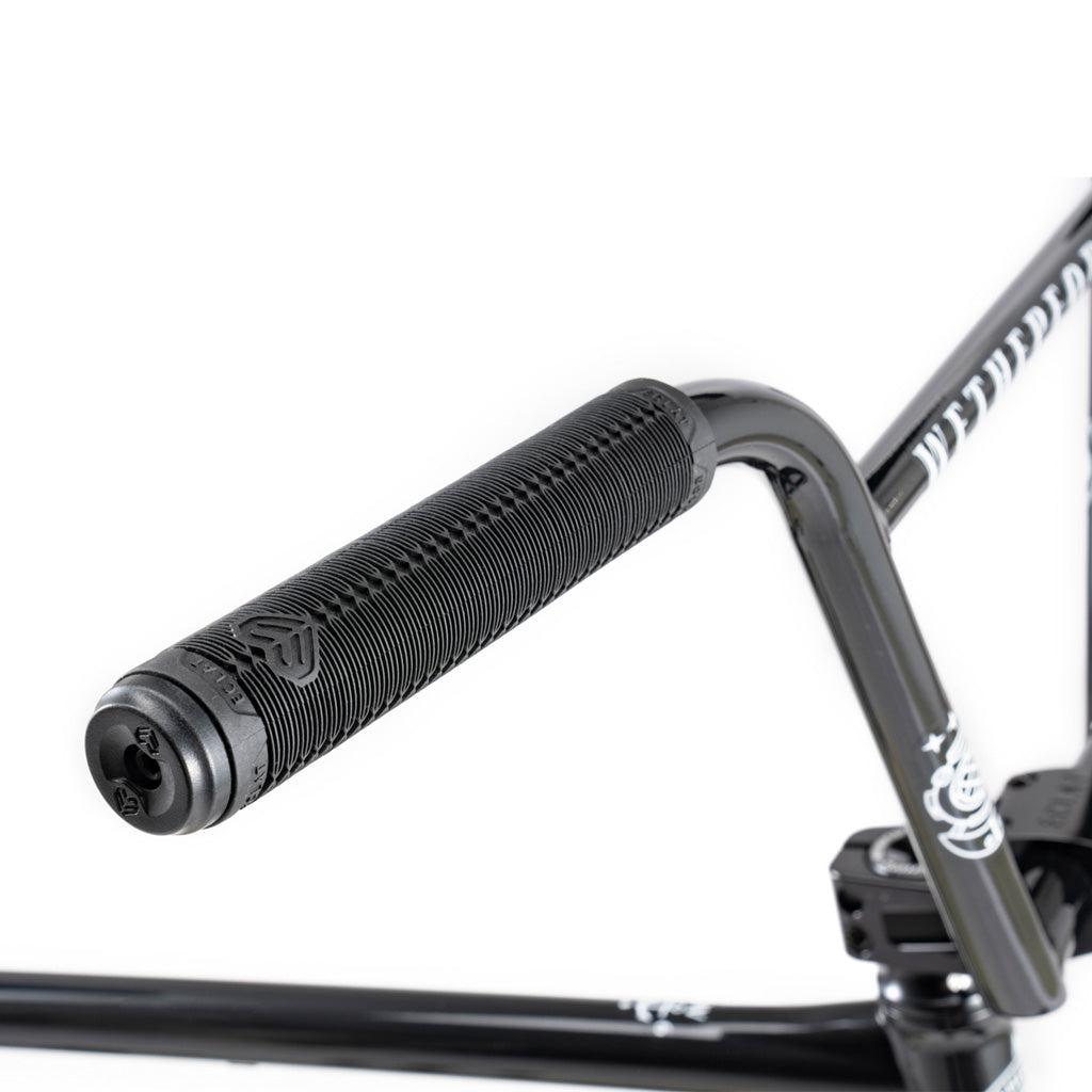 Close-up of the Wethepeople Battleship 20 Inch Bike's black BMX handlebar, featuring a textured rubber grip and visible Eclat branding on the components and handlebar stem.