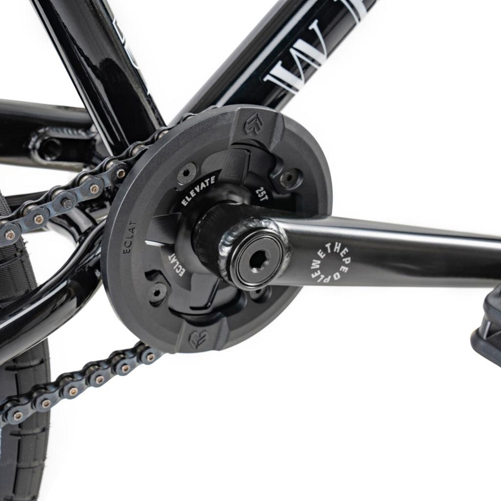Close-up of the Wethepeople Battleship 20 Inch Bike crankset with Eclat components, showing the chain, chainring, and pedal arm. "ECLAT" and "WETHEPEOPLE" logos are visible on the black parts.