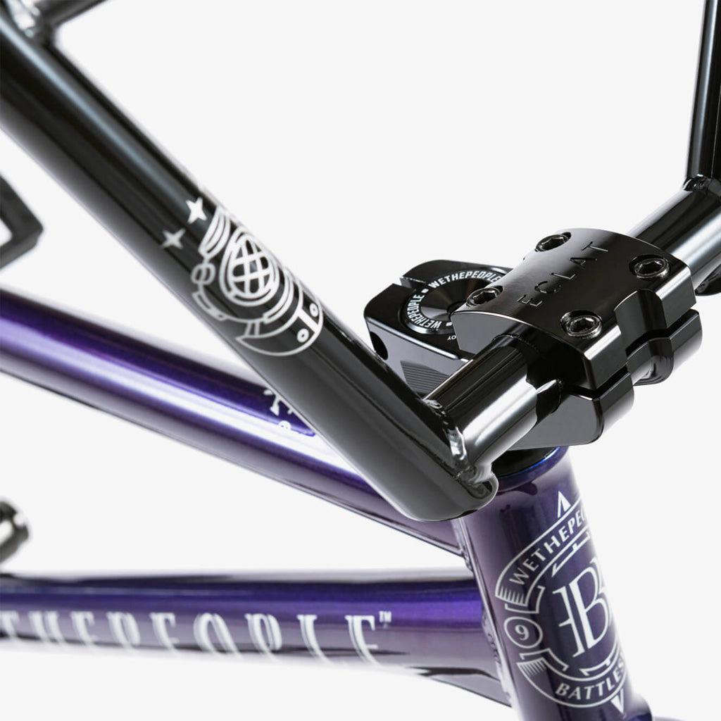 Close-up of the Wethepeople Battleship 20 Inch Bike's black and purple front frame and handlebar stem, showing Eclat components, logos, and durable Chromoly construction.
