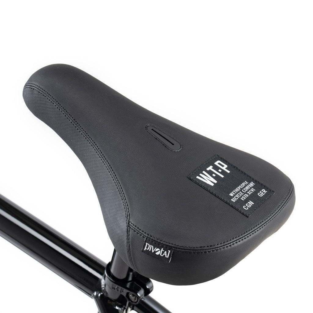 Close-up of a black bicycle seat with white "WTP" branding and text label, mounted on a black post—perfect for the Wethepeople Battleship 20 Inch Bike equipped with Eclat parts and a strong Chromoly frame.
