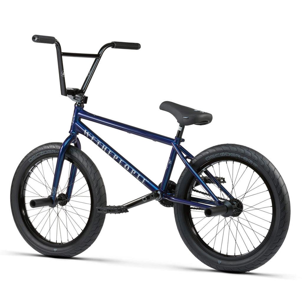 The Wethepeople Battleship 20 Inch Bike features a dark blue chromoly frame, black tires and seat, front and rear stunt pegs, premium Eclat components, all viewed from a rear side angle.