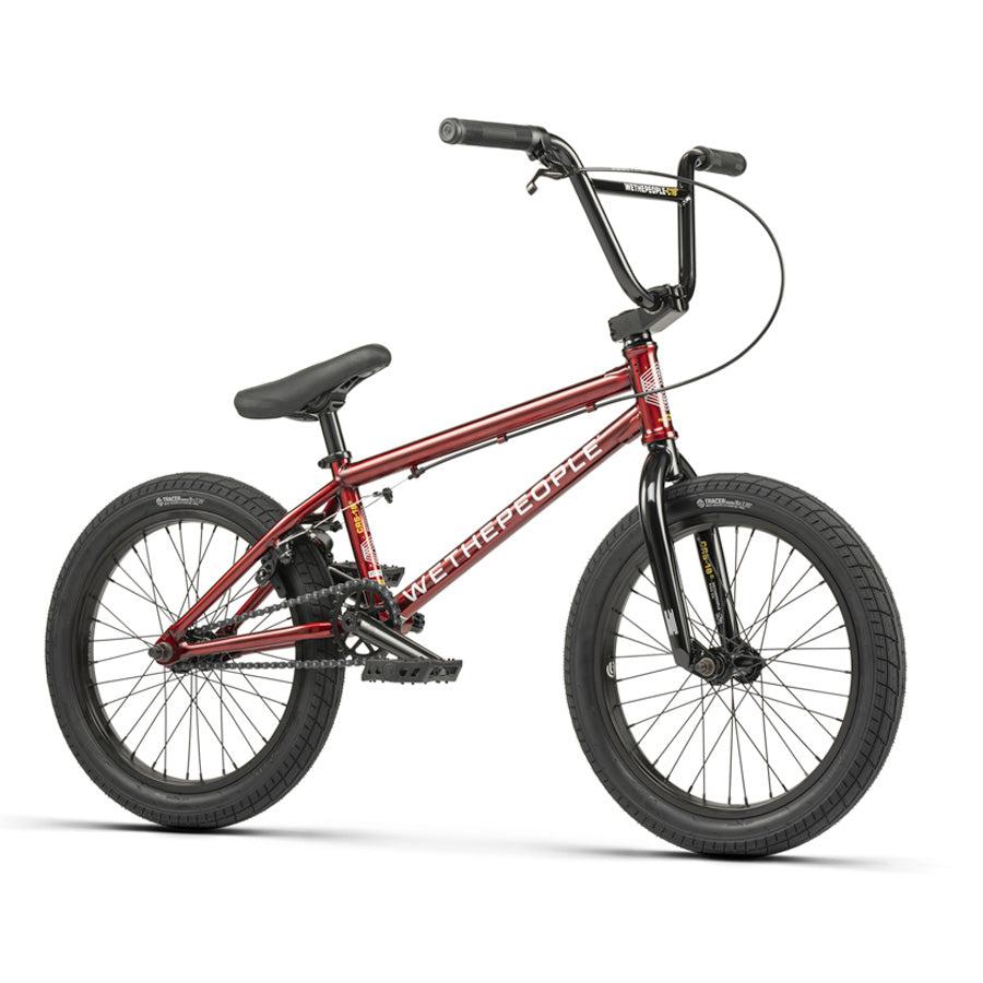 The Wethepeople CRS 18 Inch Bike, shown in red and black with thick tires, a padded seat, and straight handlebars, is displayed from the side against a plain white background.