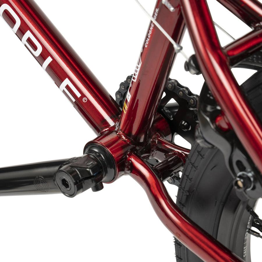 Close-up view of the Wethepeople CRS 18 Inch Bike frame, highlighting the bottom bracket area, crank arm, chainring, and part of the rear wheel with tire.