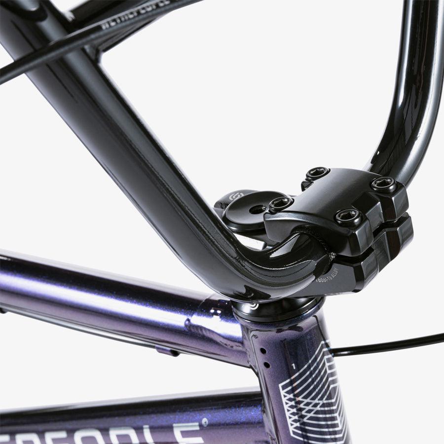 Close-up of the Wethepeople CRS 18 Inch Bike’s handlebar and stem on a metallic purple frame with geometric details, highlighting the premium design of this 18-inch BMX.