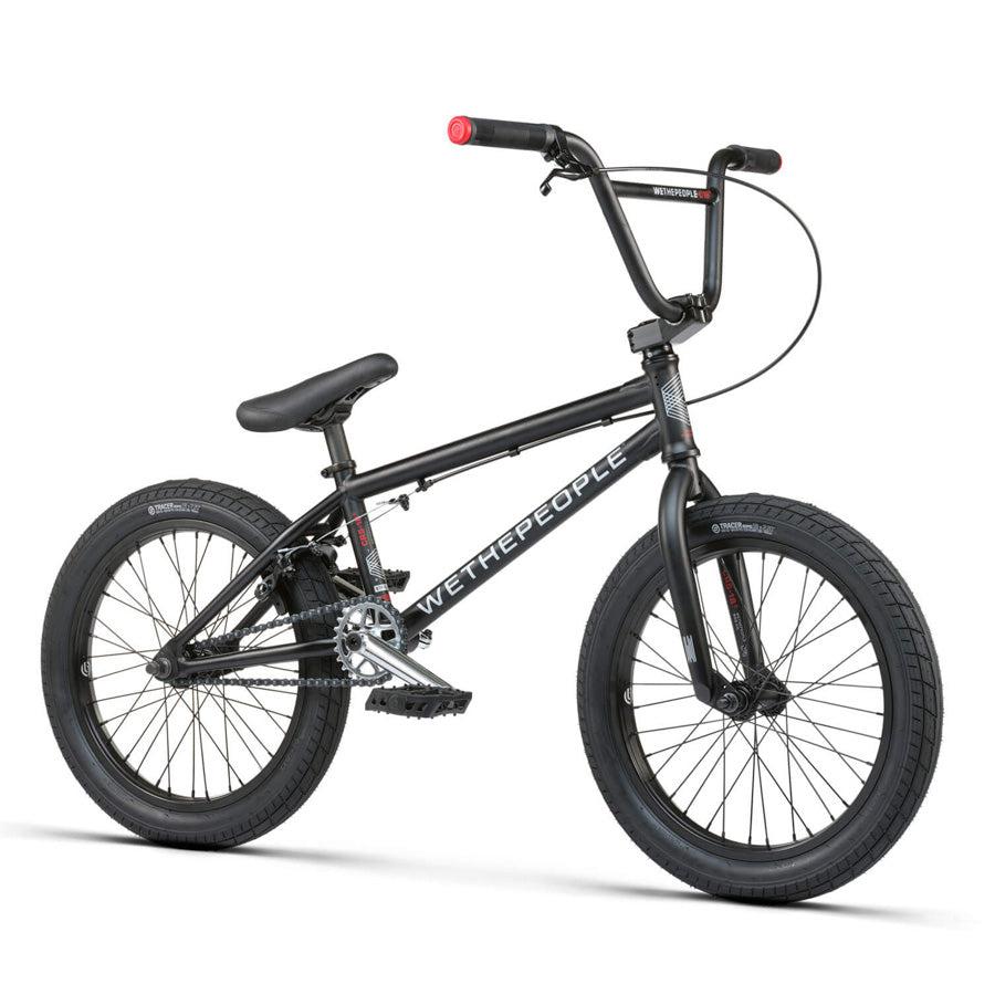 The Wethepeople CRS 18 Inch Bike is a black kids BMX with an 18" frame, straight top tube, thick tires, upright handlebars, plastic pedals, and "WeThePeople" branding—ideal for young riders.