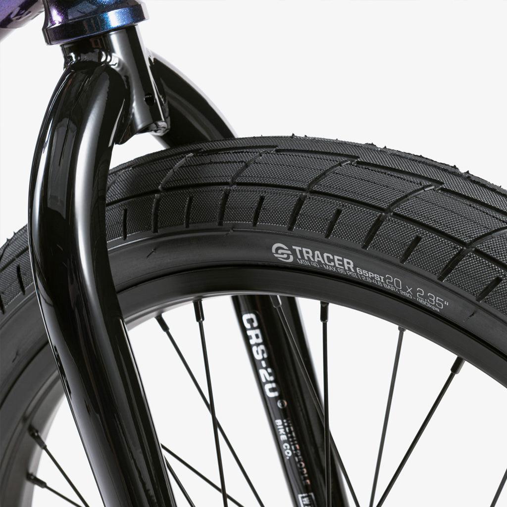 A close up of a purple BMX tire on a white background, featuring the Wethepeople CRS 20 Inch Bike.