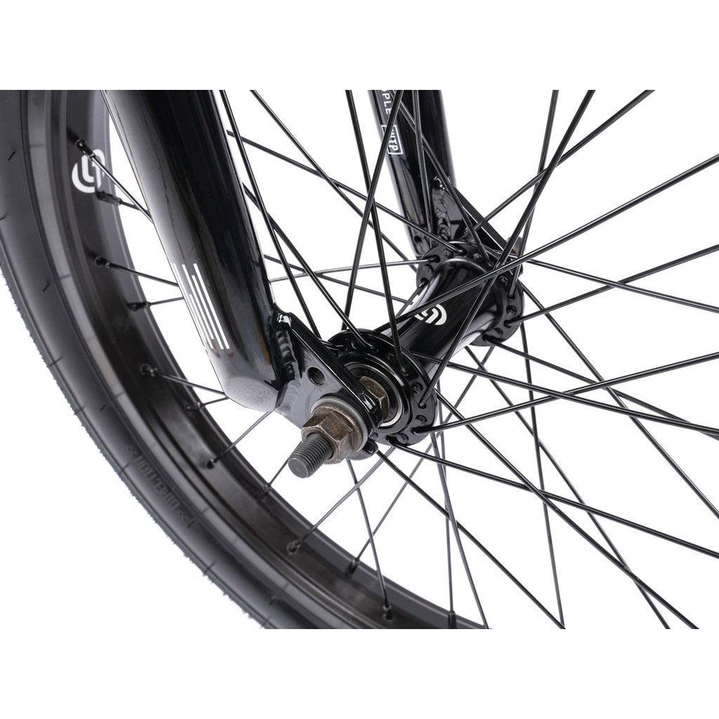Close-up view of the Wethepeople CRS FS 18 Inch Bike wheel, featuring black spokes, metal hub, axle nut, and tire—ideal for gyro-equipped BMX freestyle setups.