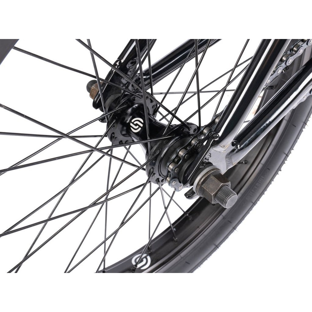 Close-up of Wethepeople CRS FS 18 Inch Bike rear wheel, featuring metal spokes, hub, axle nuts, tire section, and gyro system.