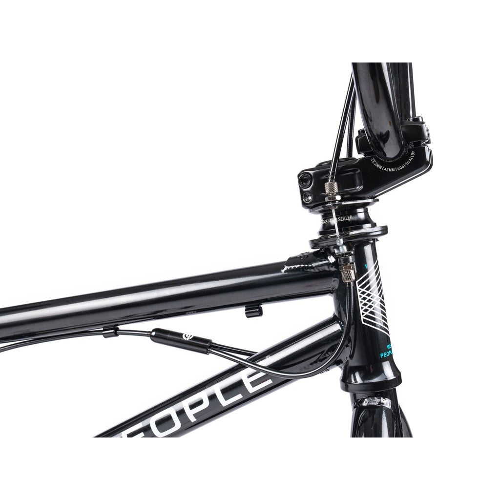 Close-up of the Wethepeople CRS FS 18 Inch Bike's black front frame, headset, and brake cable, featuring white geometric graphics and partial text on the frame.