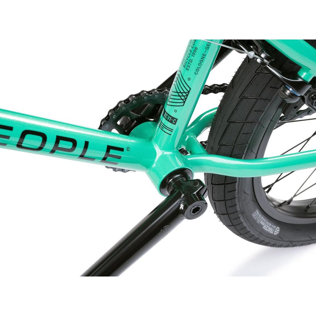 Close-up view of the mint green Wethepeople CRS FS 18 Inch Bike frame, featuring the chain, crank arm, rear tire, and part of the word "PEOPLE" on this gyro-equipped BMX freestyle ride.
