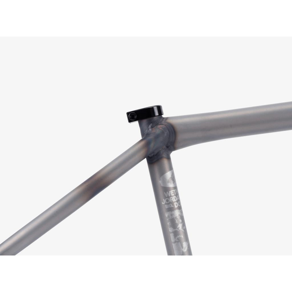 Close-up of the Wethepeople Doomsayer Frame’s seat tube junction, featuring welded metal joints and a black seat post clamp—built for street riders who value progressive geometry—all on a white background.