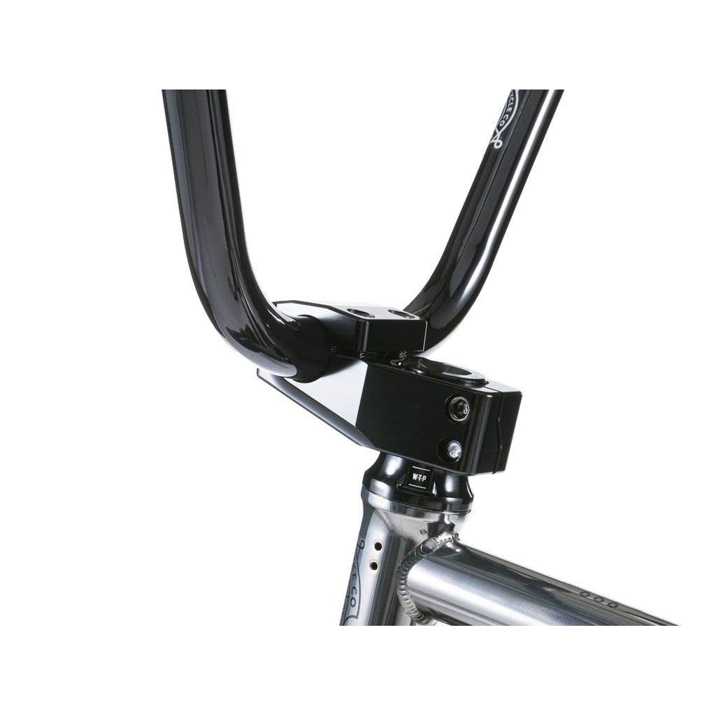 Close-up of a black BMX handlebar on a Wethepeople Envy 20 Inch Bike. The handlebar is mounted on a silver stem, seamlessly attached to the frame, highlighting one of the BMX masterpieces.