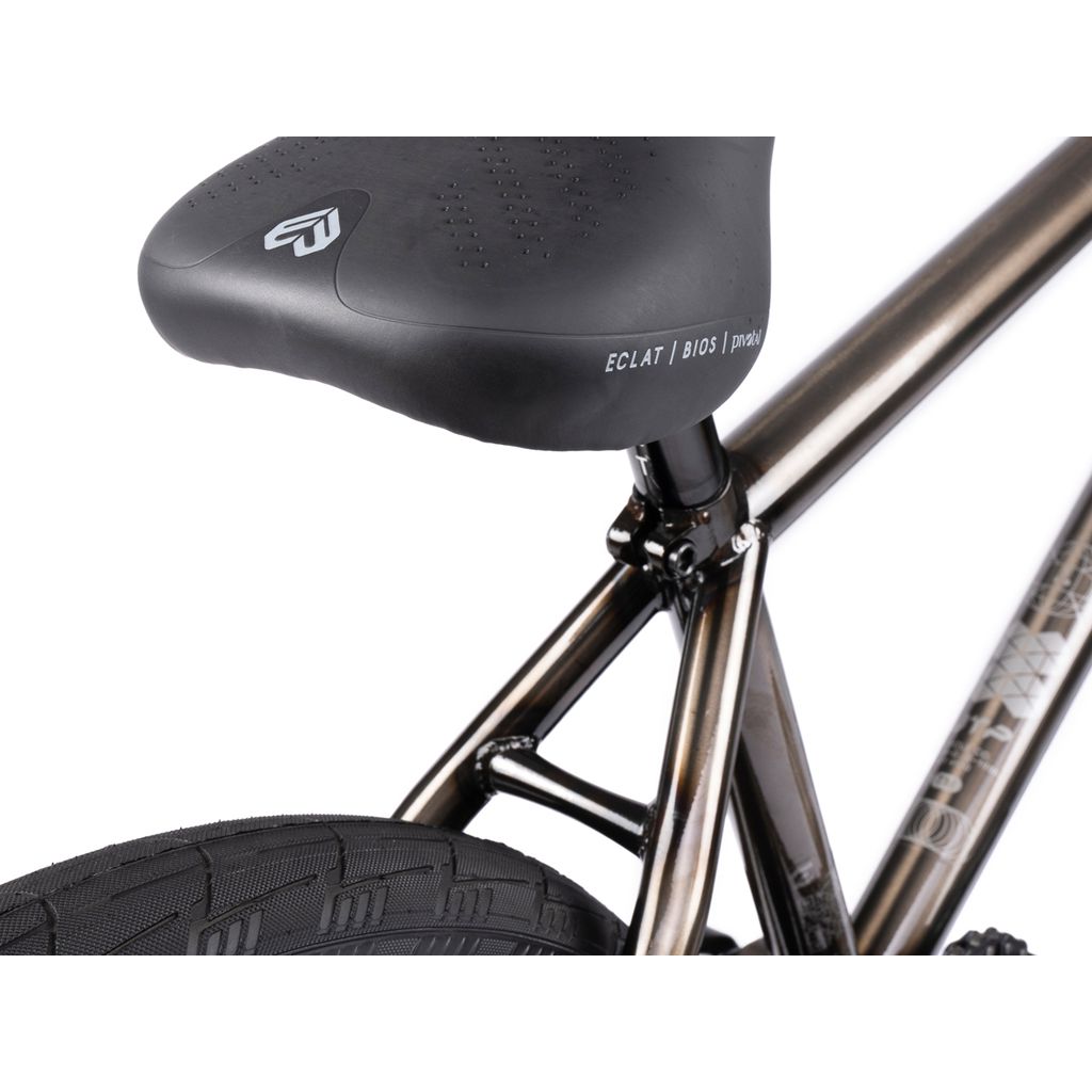 Close-up of a bicycle seat and rear frame. The black seat, with white branding, sits on a sleek Wethepeople Envy 20 Inch Bike. The frame and tire showcase elegant design, highlighting the BMX masterpiece it truly is.