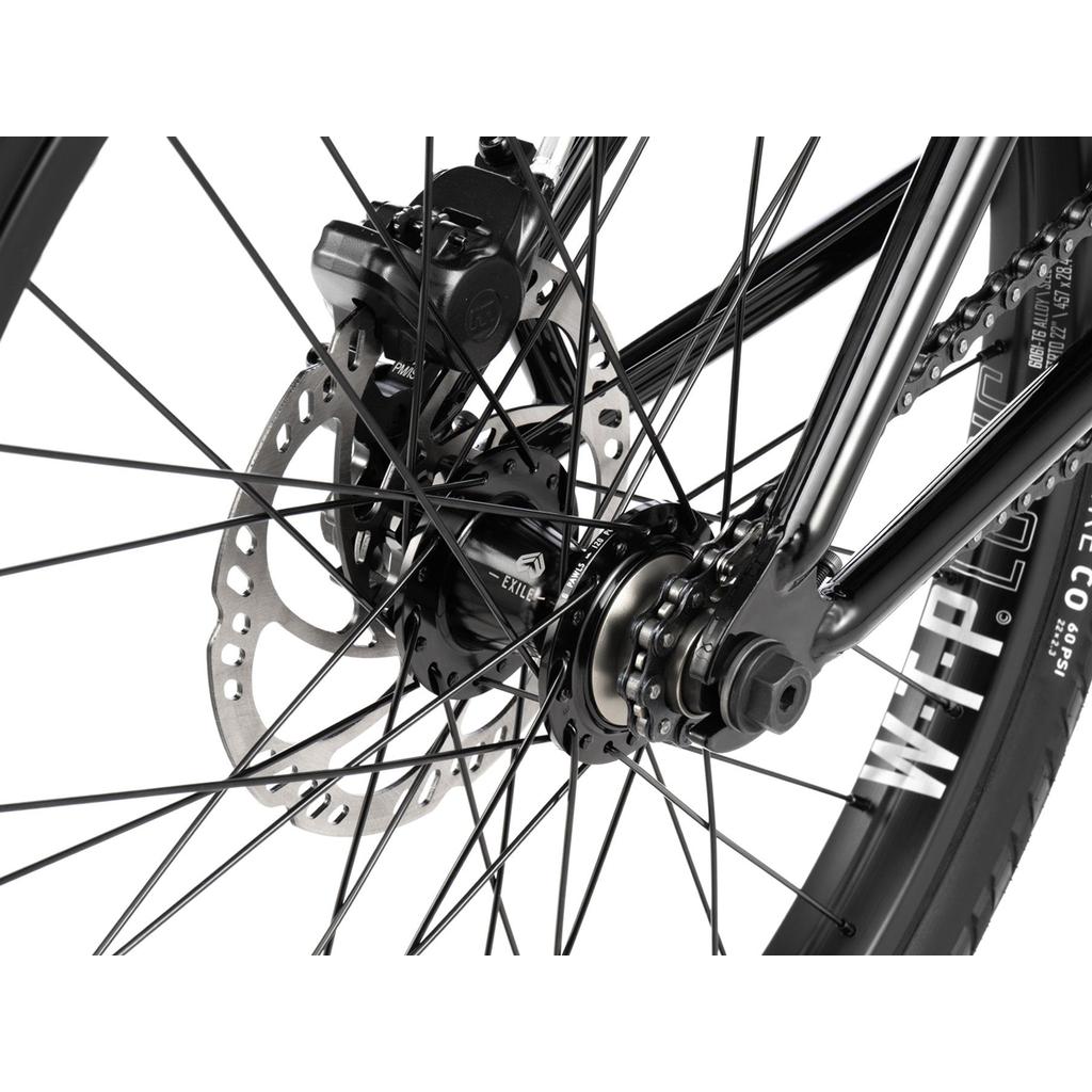 Close-up of the Wethepeople Havoc 22 Inch Bike’s rear wheel, highlighting the disc brake rotor, caliper, spokes, axle, and tire with visible branding.