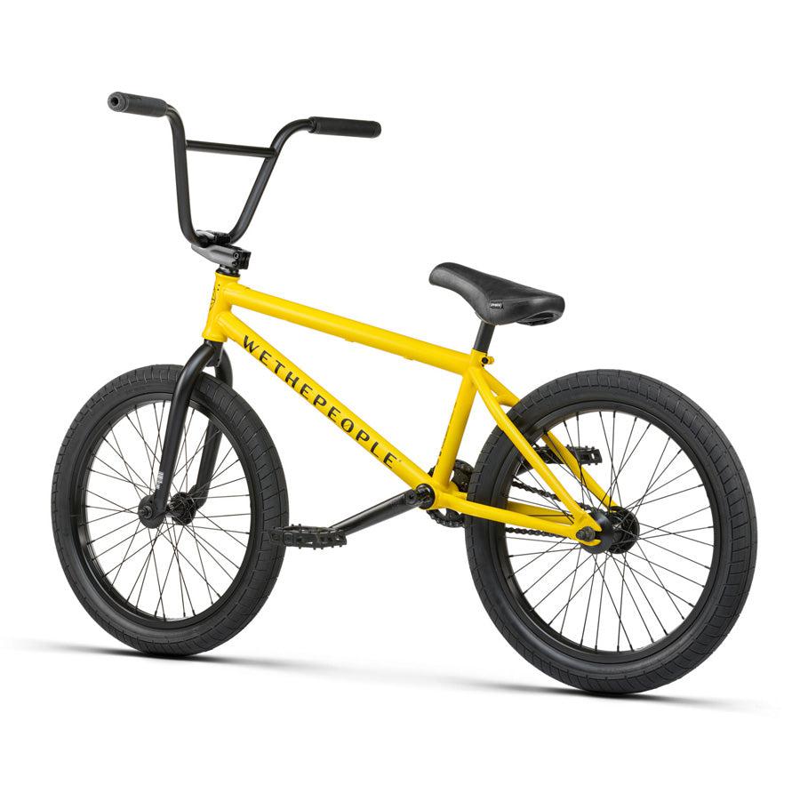 A yellow Wethepeople Justice 20 Inch Bike with black handlebars, seat, and tires. The brand name "Wethepeople" is visible on the frame, showcasing top-of-the-line BMX components.