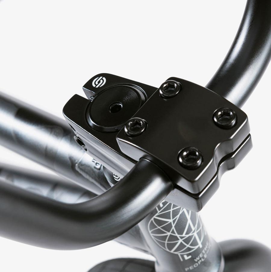 Close-up view of a bicycle handlebar and stem, featuring a black four-bolt clamp securing the handlebar. The Wethepeople Justice 20 Inch Bike boasts top-of-the-line BMX components for an exceptional ride.