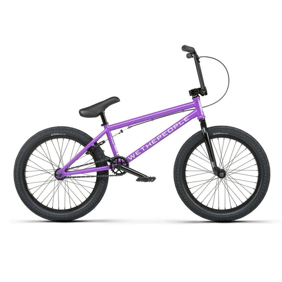 The Wethepeople Nova 20 Inch BMX bike, in purple, showcases "WETHEPEOPLE" on its frame. It features black handlebars and tires with Salt Rookie Cranks, all set against a white background.