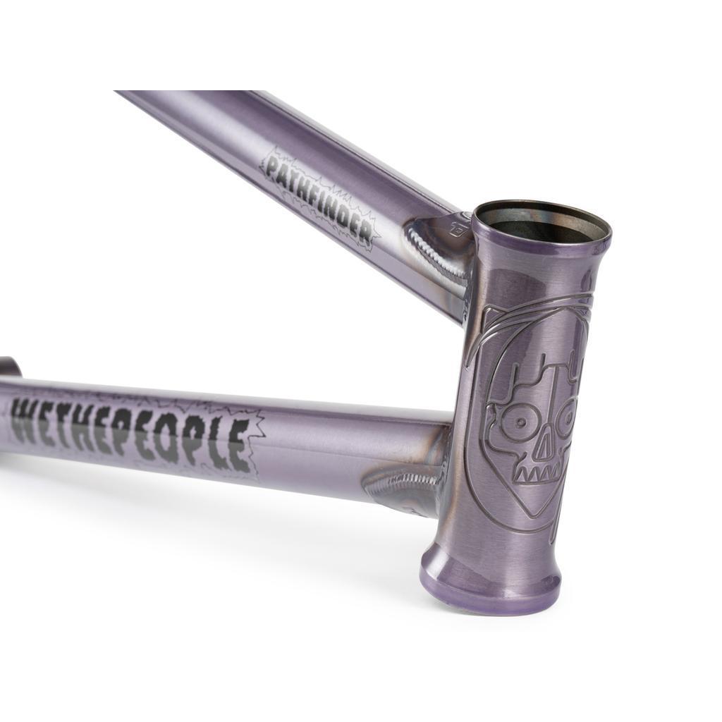 Close-up of a metallic purple Wethepeople Pathfinder Frame BMX bike with bold "WETHEPEOPLE" branding and a skull graphic on the head tube, designed in collaboration with Felix Prangenberg.