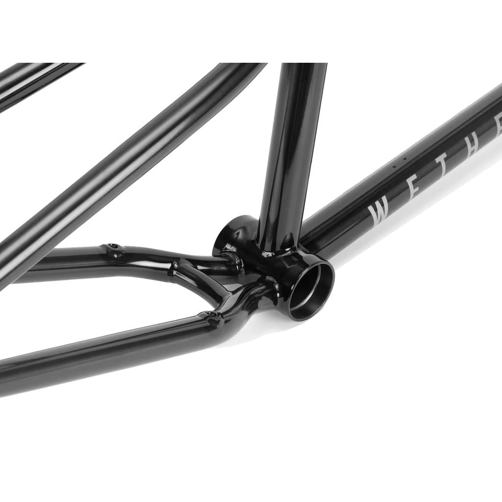 Close-up of the Wethepeople Patrol Frame in black, highlighting the bottom bracket, chain stay, and seat tube junction. The visible "WETHER" accentuates rear triangle clearance for trail and transition riding.