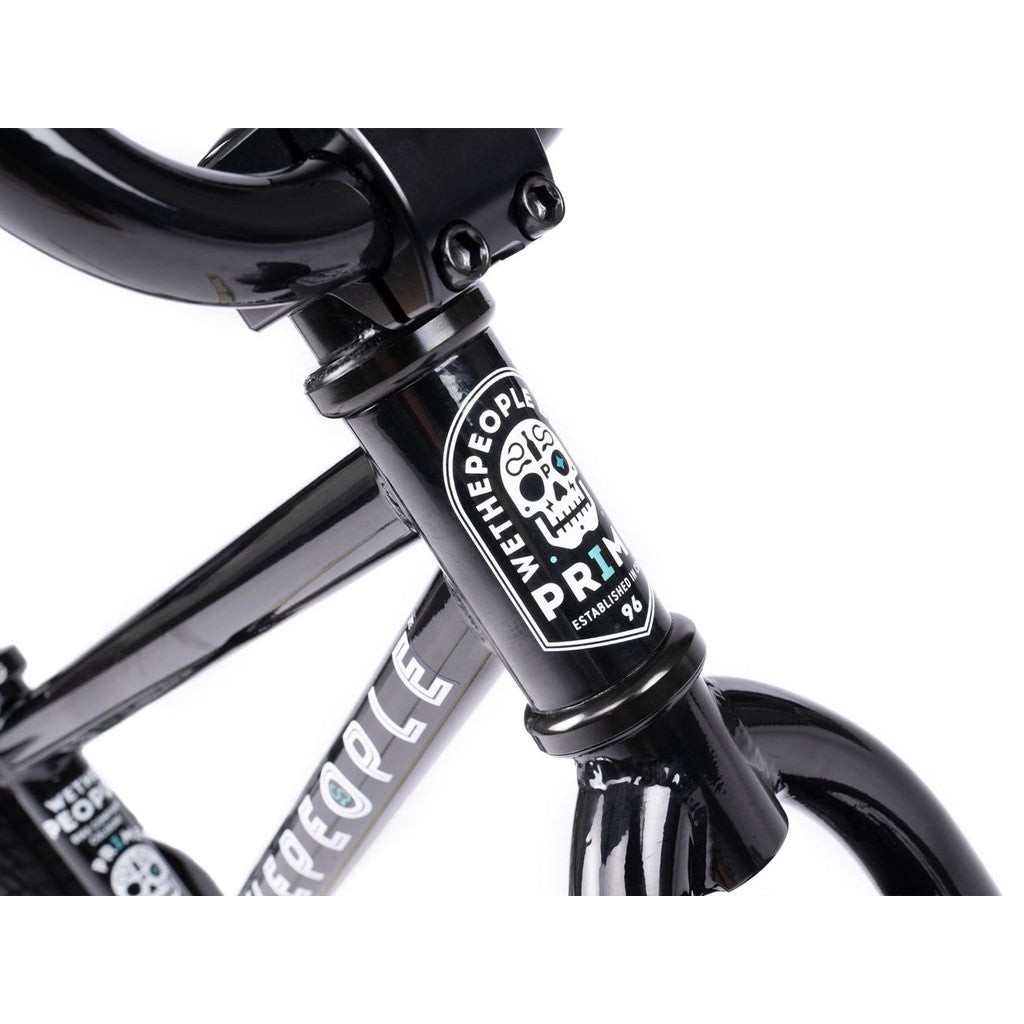Close-up of a black Wethepeople Prime 12 Inch Balance Bike frame, showcasing the "Wethepeople Prime" logo and a bold skull graphic on the head tube.