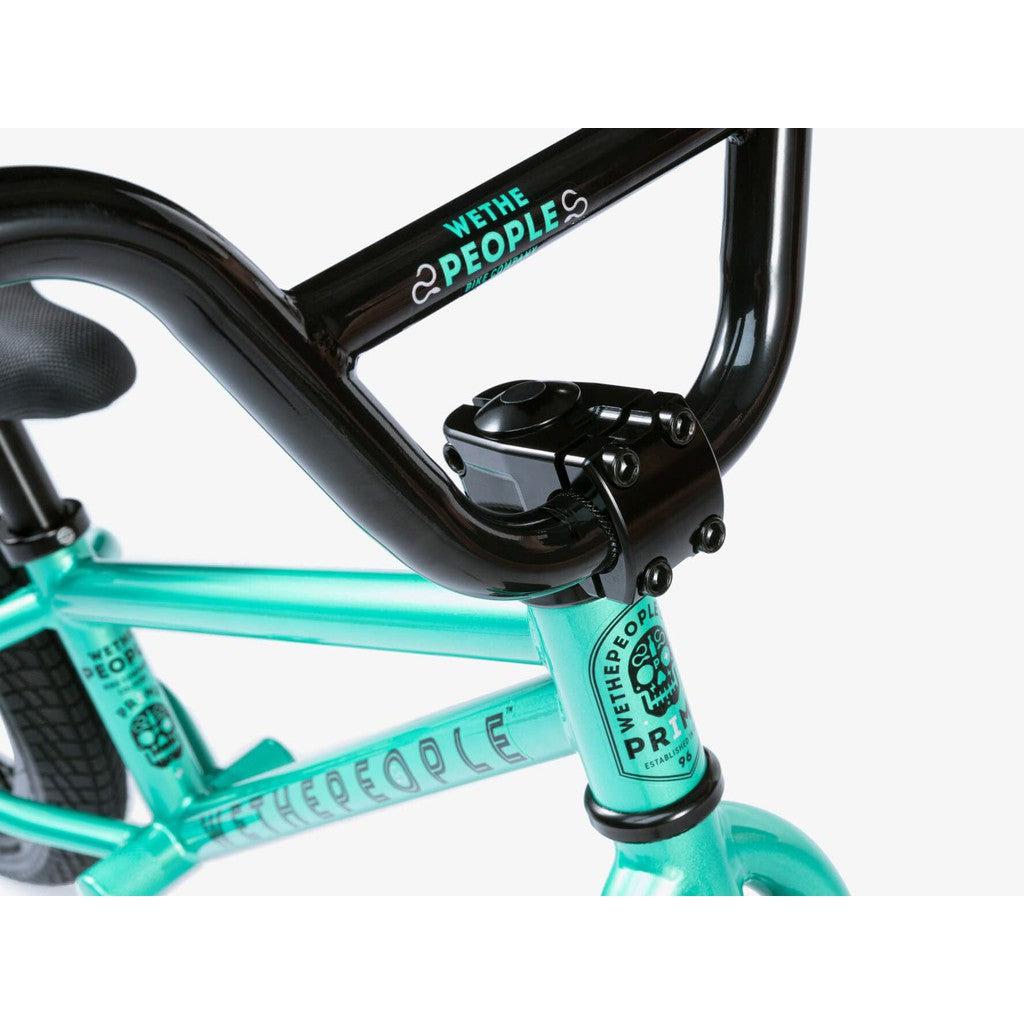 Close-up of a turquoise Wethepeople Prime 12 Inch Balance Bike frame and black handlebars, featuring "Wethepeople" branding on both the frame and stem.