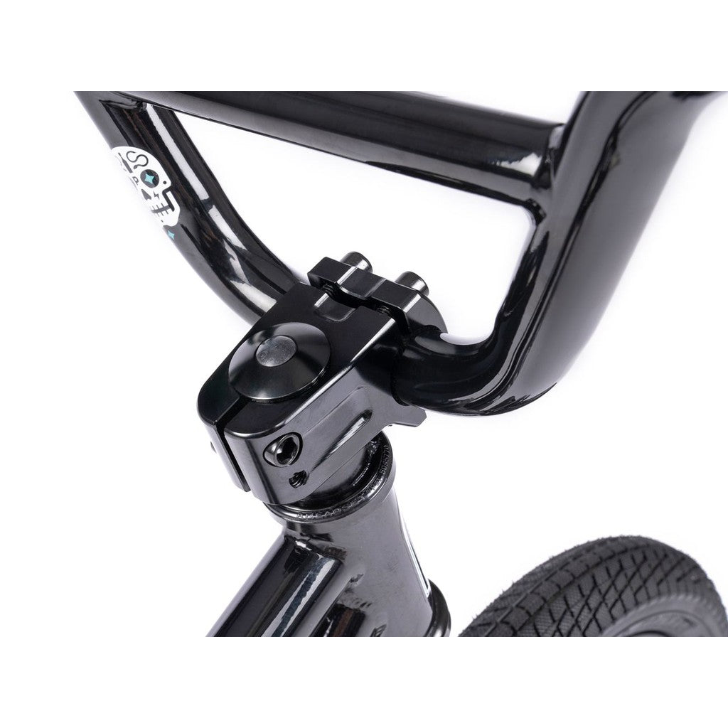 Close-up of a black handlebar, stem, and front tire of the Wethepeople Prime 12 Inch Balance Bike set against a white background.