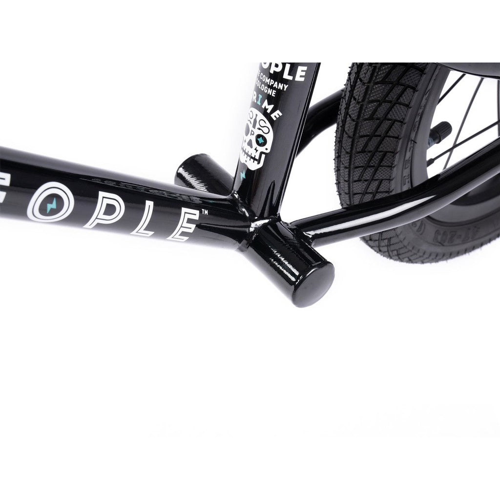 Close-up view of a black Wethepeople Prime 12 Inch Balance Bike frame with a partial logo, small graphic sticker, and rear tire visible against a white background.