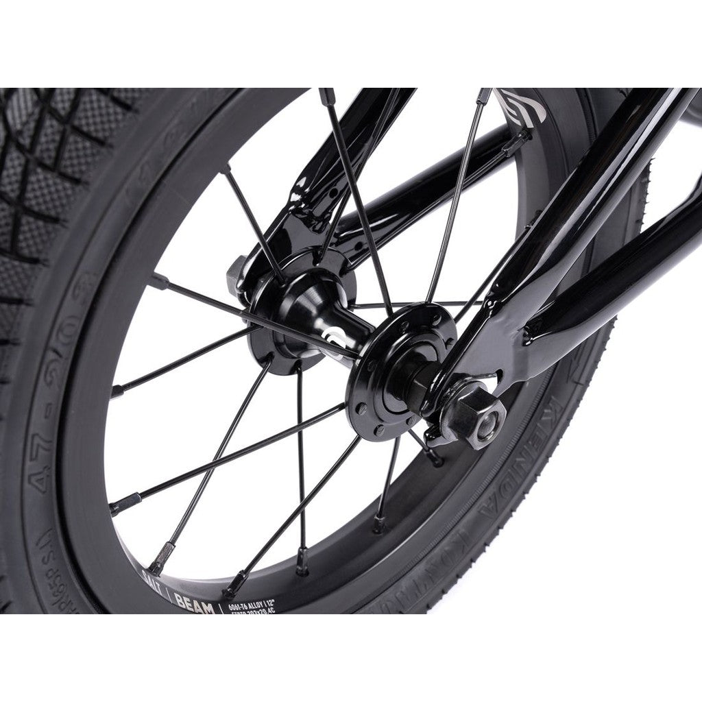 Close-up view of a Wethepeople Prime 12 Inch Balance Bike's front wheel, displaying the tire, spokes, hub, and fork against a white background.