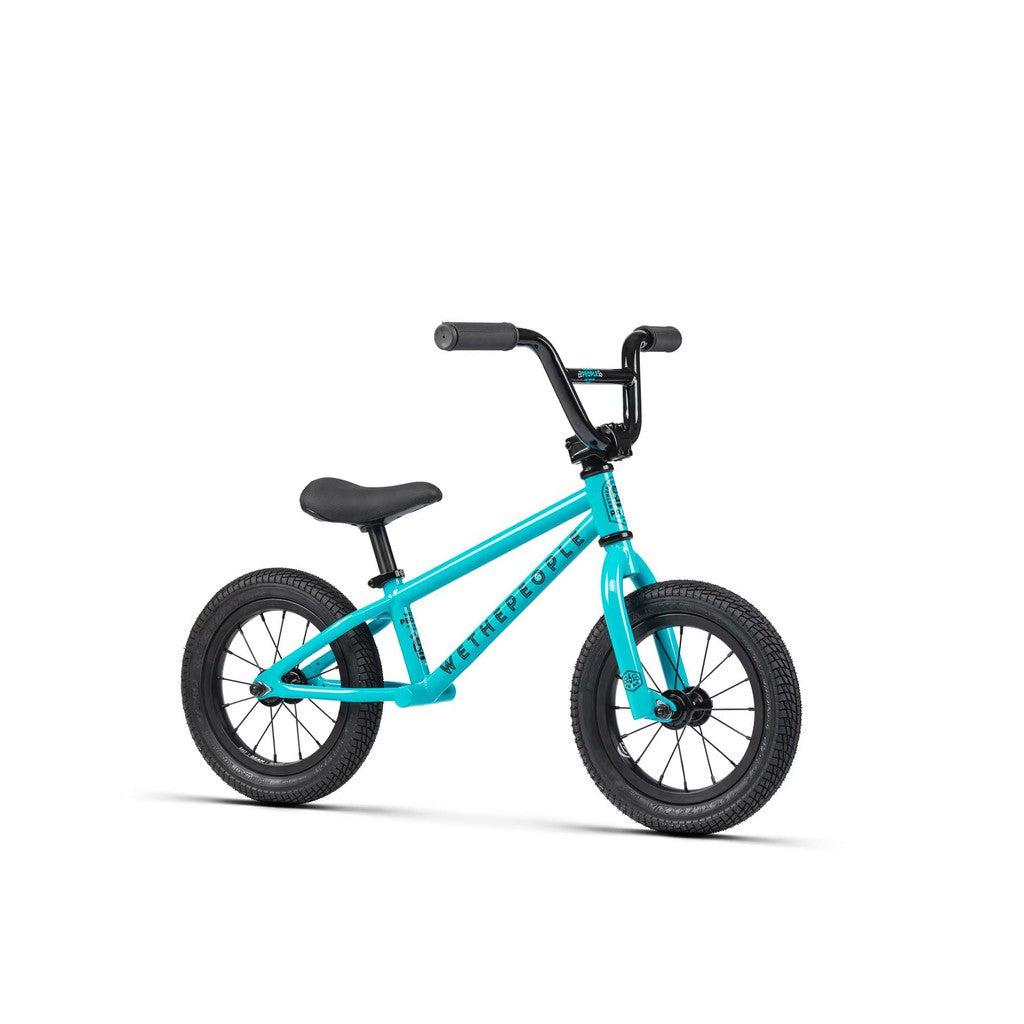 The Wethepeople Prime 12 Inch Balance Bike is a small blue bike with black handlebars, saddle, and tires, shown against a white background—ideal for young BMX enthusiasts who are just starting out.