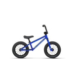 The Wethepeople Prime 12 Inch Balance Bike is a small blue balance bike with BMX-style black handlebars, seat, and tires, shown in profile on a plain white background.