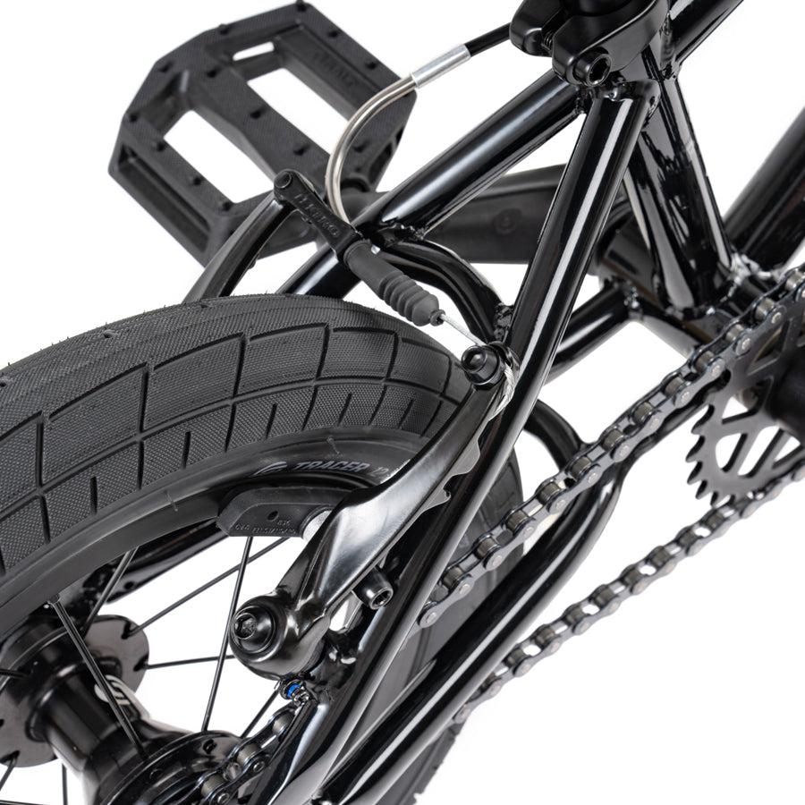 A close up of a black Wethepeople Prime Drive 12 Inch Bike with chains and drivetrain.