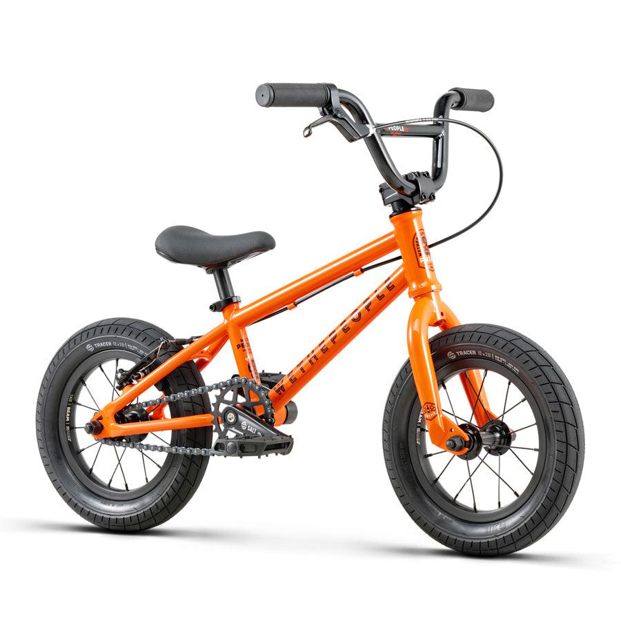 A vibrant orange Wethepeople Prime Drive 12 Inch Bike on a clean white background.