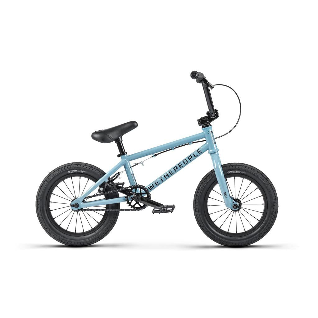 The Wethepeople Riot 14 Inch Bike is a small, light blue BMX-style bike with black handlebars, seat, and tires, shown in profile on a white background.