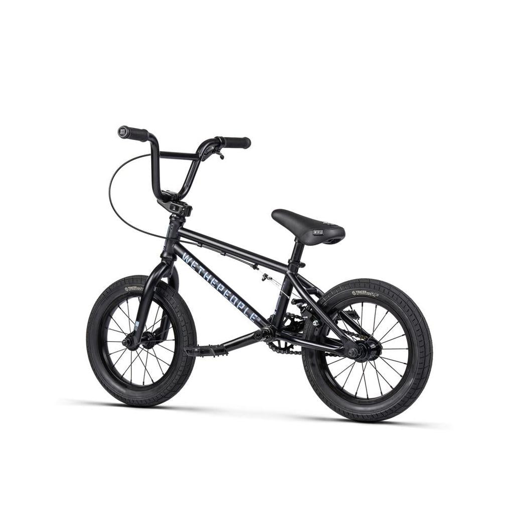 A Wethepeople Riot 14 Inch Bike, a small black BMX-style bicycle featuring thick tires, Chromoly cranks, padded seat, and high handlebars, is photographed against a plain white background.