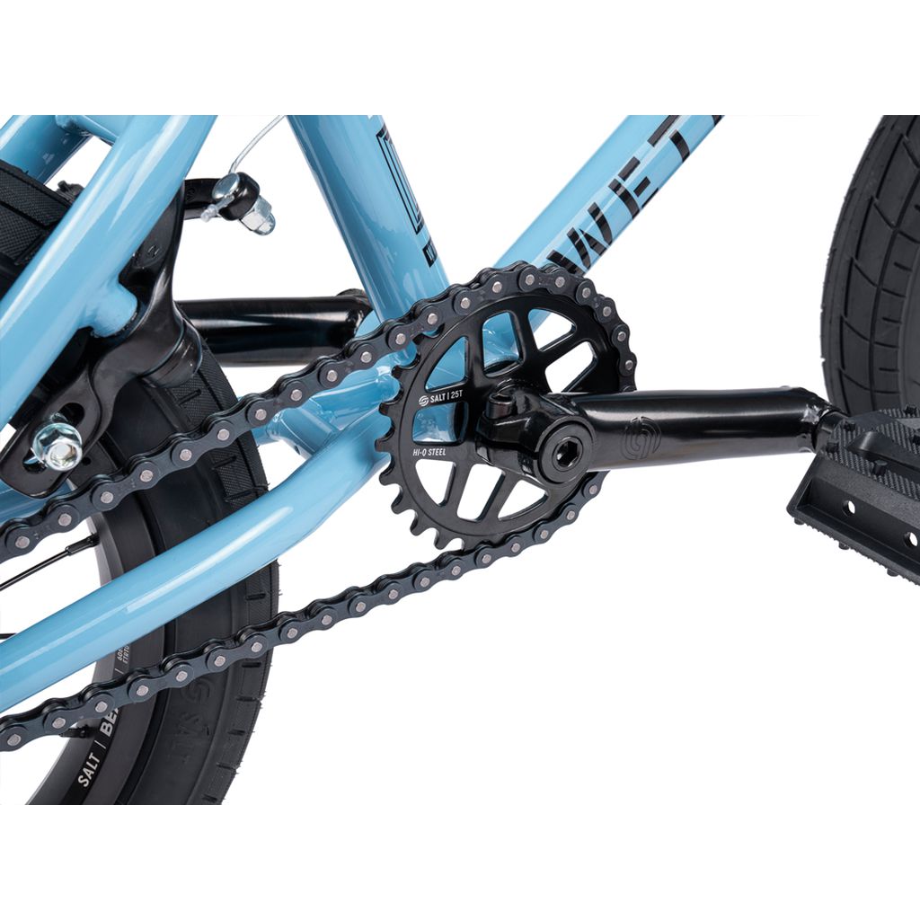 Close-up view of the Wethepeople Riot 14 Inch Bike’s drivetrain with chain, Chromoly Cranks, and pedal attached to its blue frame.