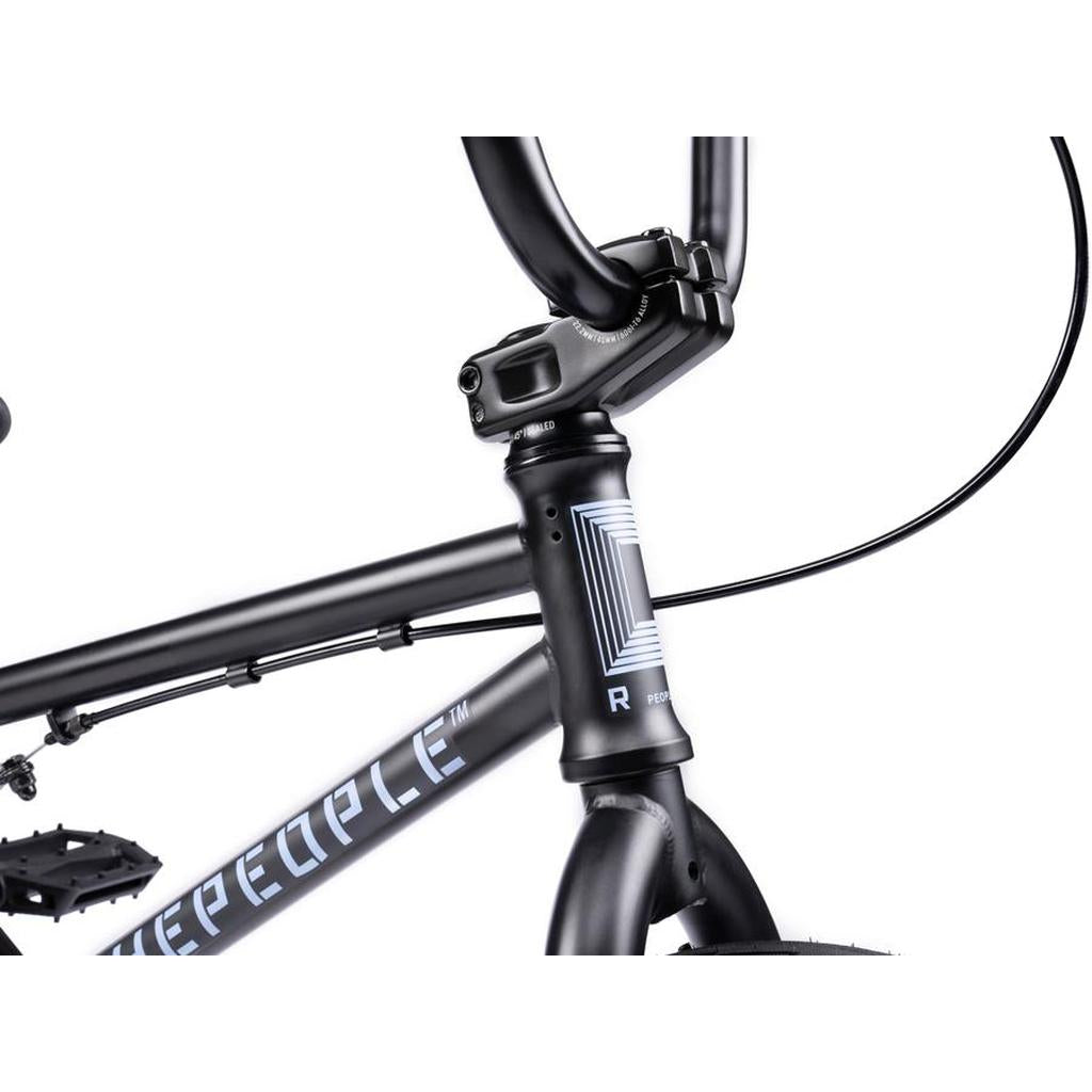 Close-up of the front section of a black Wethepeople Riot 14 Inch Bike, showing its handlebars, stem, head tube, and part of the frame with branding and graphic details.