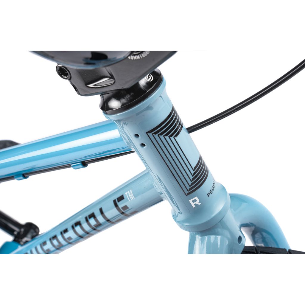 Close-up of the Wethepeople Riot 14 Inch Bike in light blue, showing the head tube, handlebars, and part of the brake cable.