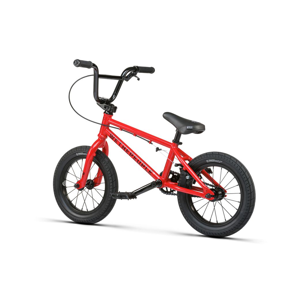 The Wethepeople Riot 14 Inch Bike is a small red BMX-style bicycle with black handlebars, seat, and tires, displayed on a white background.