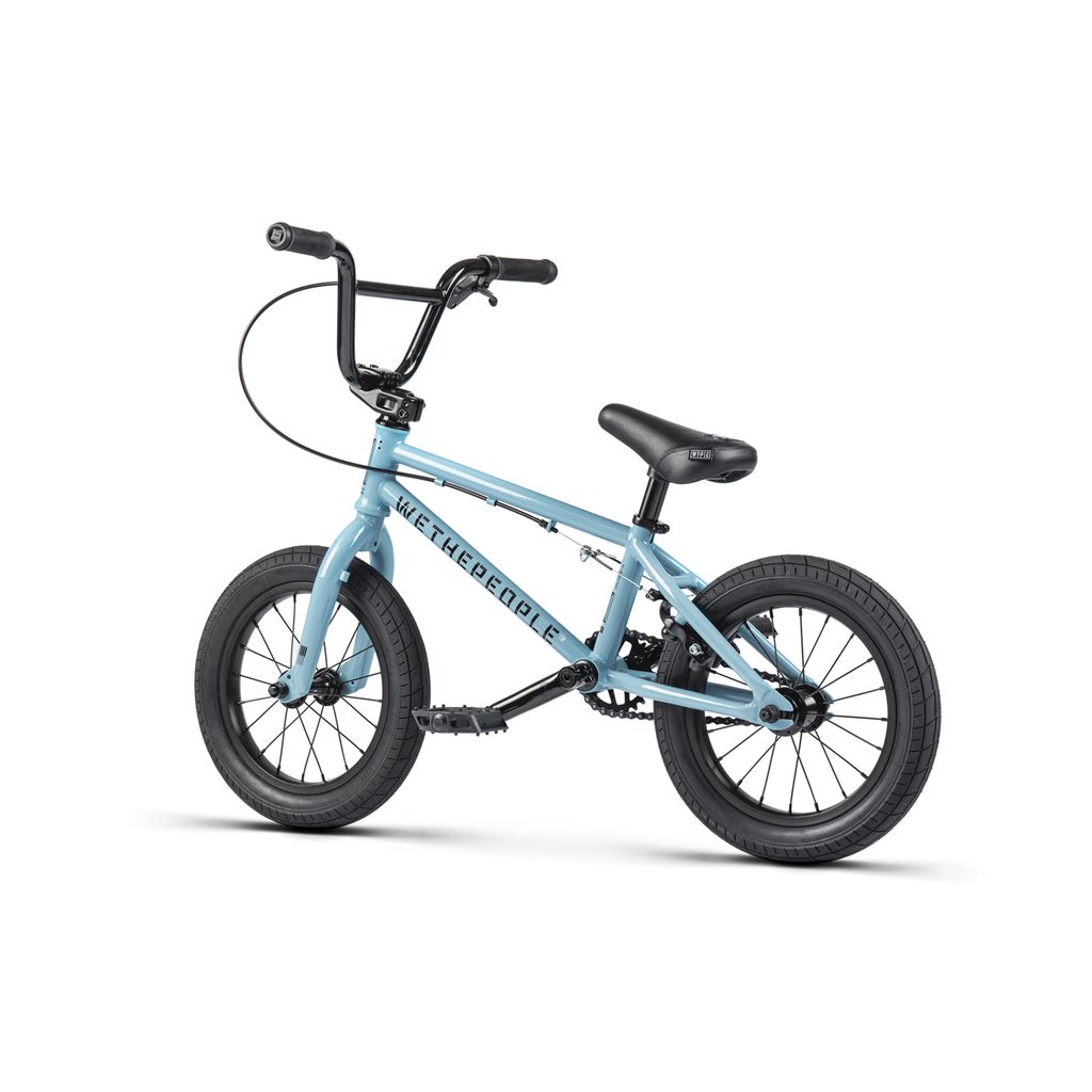 The Wethepeople Riot 14 Inch Bike is a small, light blue BMX with black handlebars, seat, and tires, featuring durable Chromoly cranks. Shown on a white background.