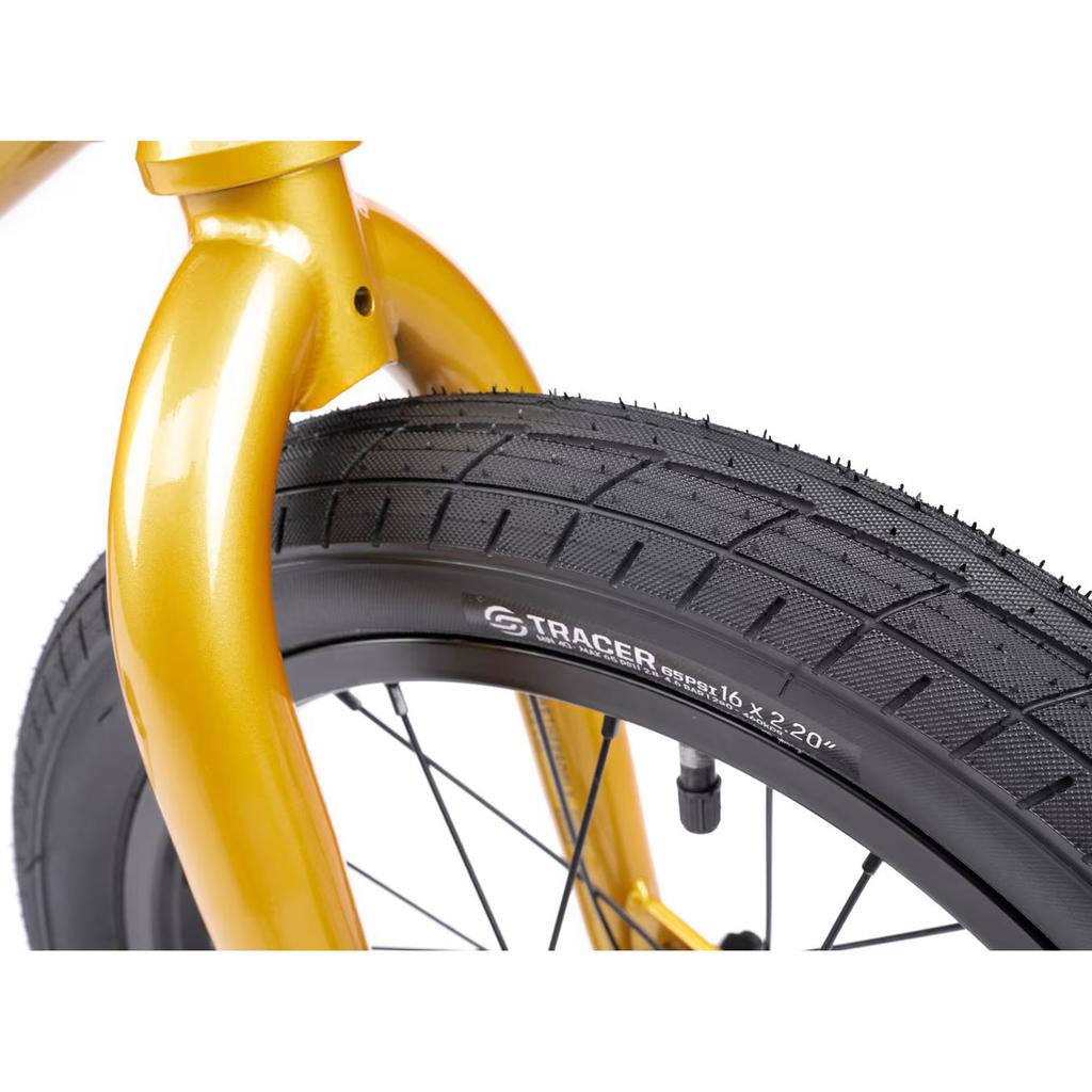 Close-up of a Wethepeople Seed 16 Inch Bike's front wheel, featuring a black treaded tire and sleek black spokes attached to a bright yellow fork.