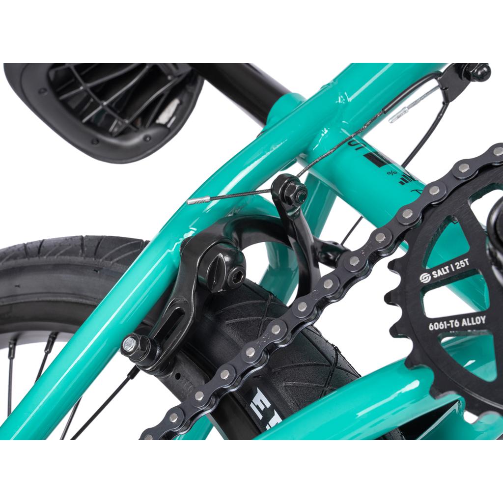 Close-up of the rear wheel, chain, sprocket, brake caliper, and seat on the turquoise Wethepeople Sinus Flatland 20 Inch Bike.
