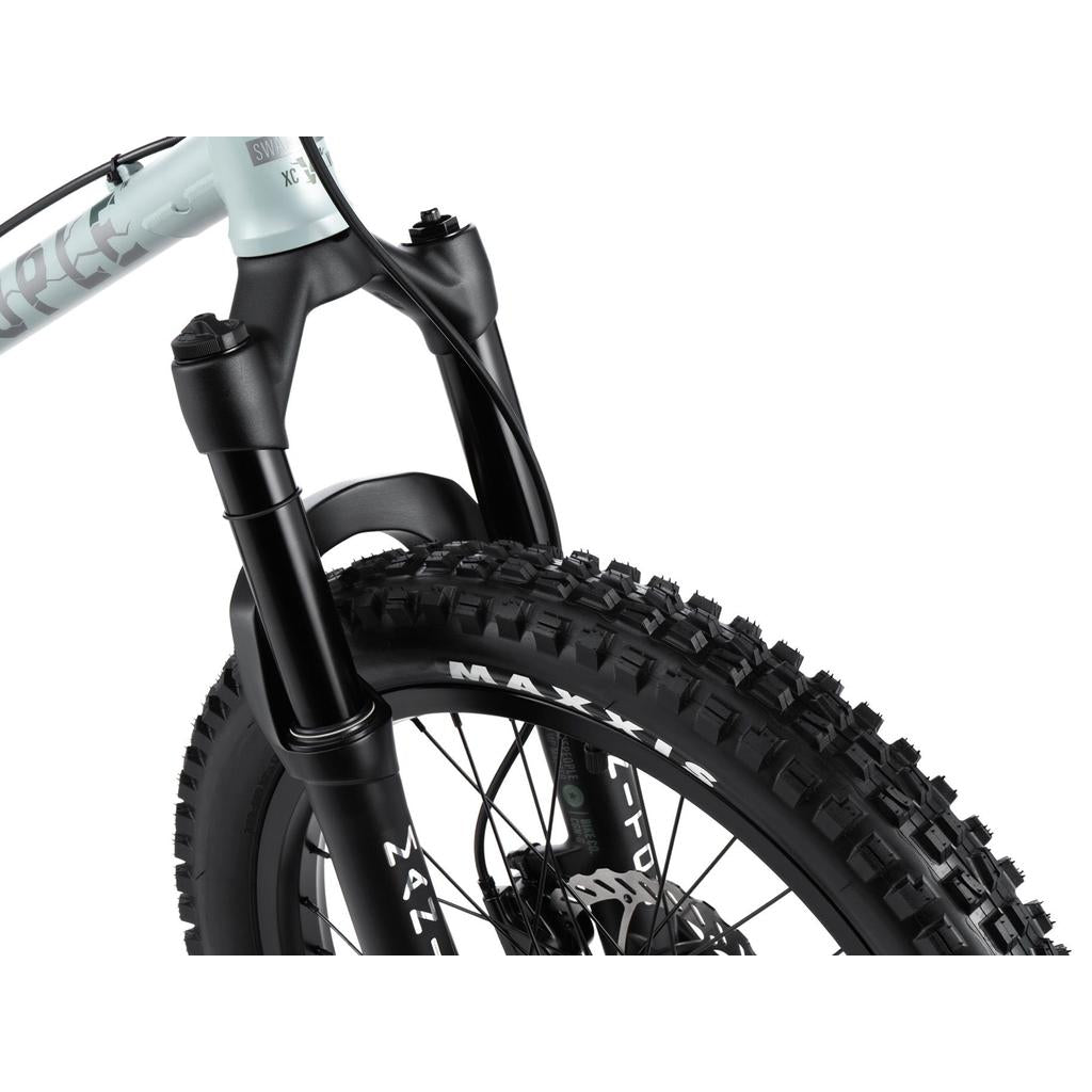 Close-up of the Wethepeople Swampmaster 20 Inch Bike's front suspension fork, thick-tread tire, and disc brake, highlighting its frame and branding—ideal for downhill mountain biking enthusiasts.