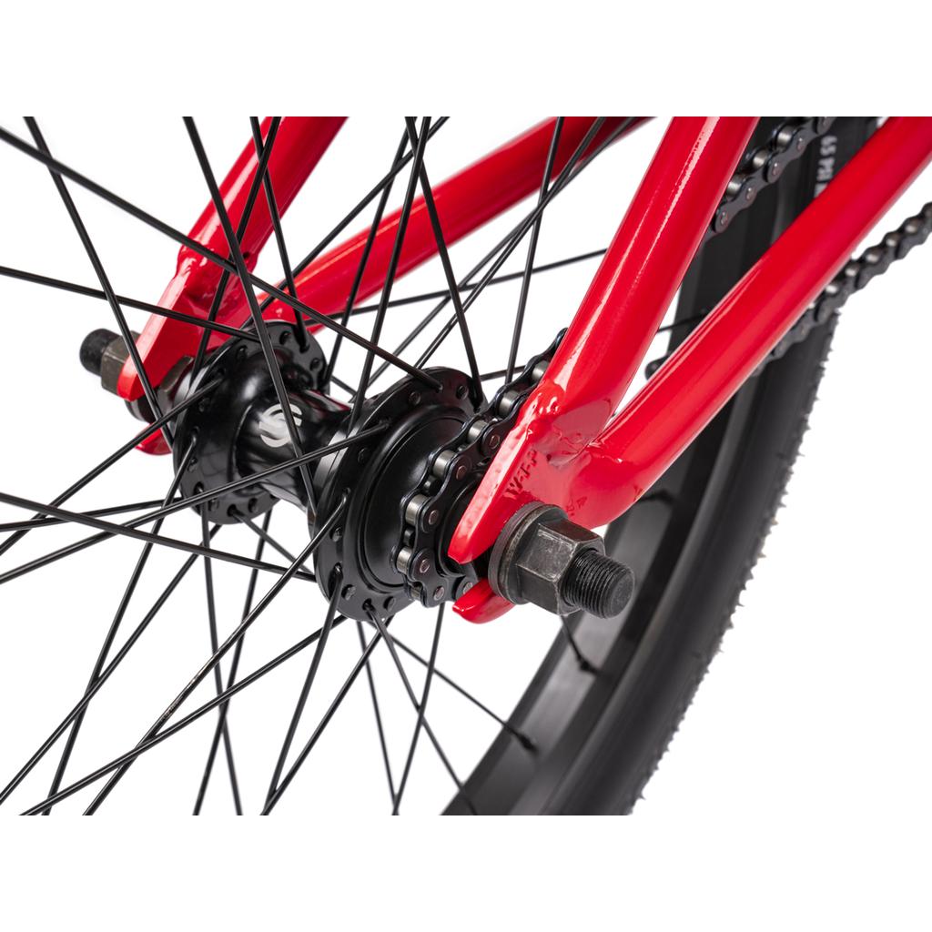Close-up of the rear wheel hub, spokes, chain, axle, and tire on a red Wethepeople Thrillseeker 20 Inch Bike.