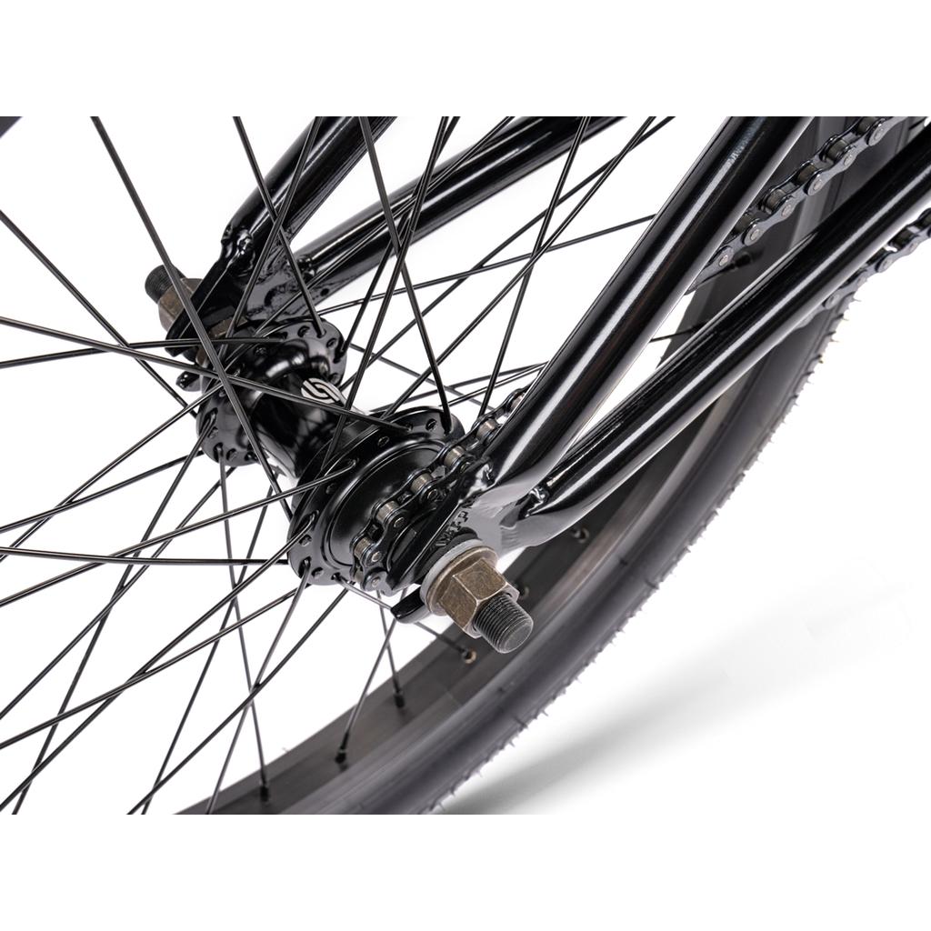 Close-up of the Wethepeople Thrillseeker 20 Inch Bike’s rear hub, displaying spokes, axle, and part of the chain against a white background.