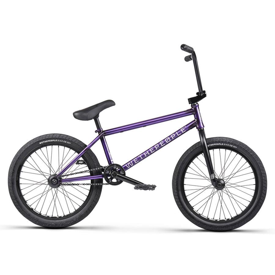 A purple Wethepeople Trust 20 Inch Cassette/Hybrid BMX bike with black tires, straight handlebars, padded seat, and "WeThePeople" on the frame is shown against a white background.