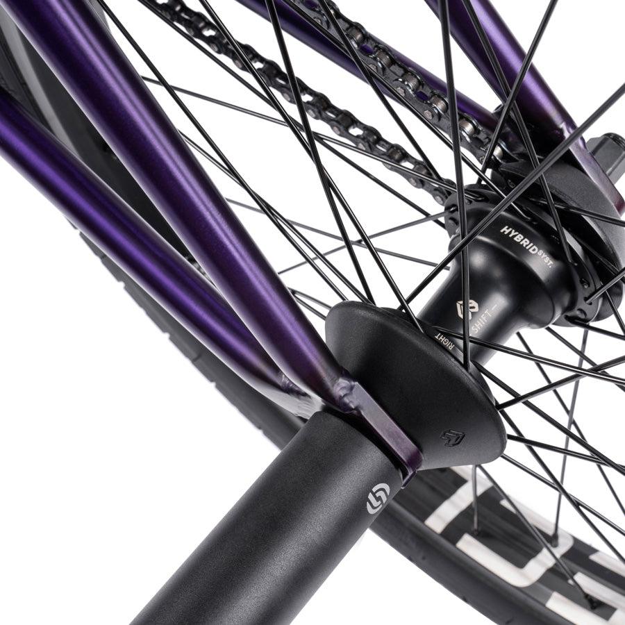 A close-up of the rear wheel on the Wethepeople Trust 20 Inch Freecoaster/Hybrid Bike showcases its intricate spokes, sturdy hub, and sleek frame, exemplifying battleship geometry in every line and angle.
